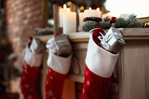 Stockings filled with gifts hanging above fireplace